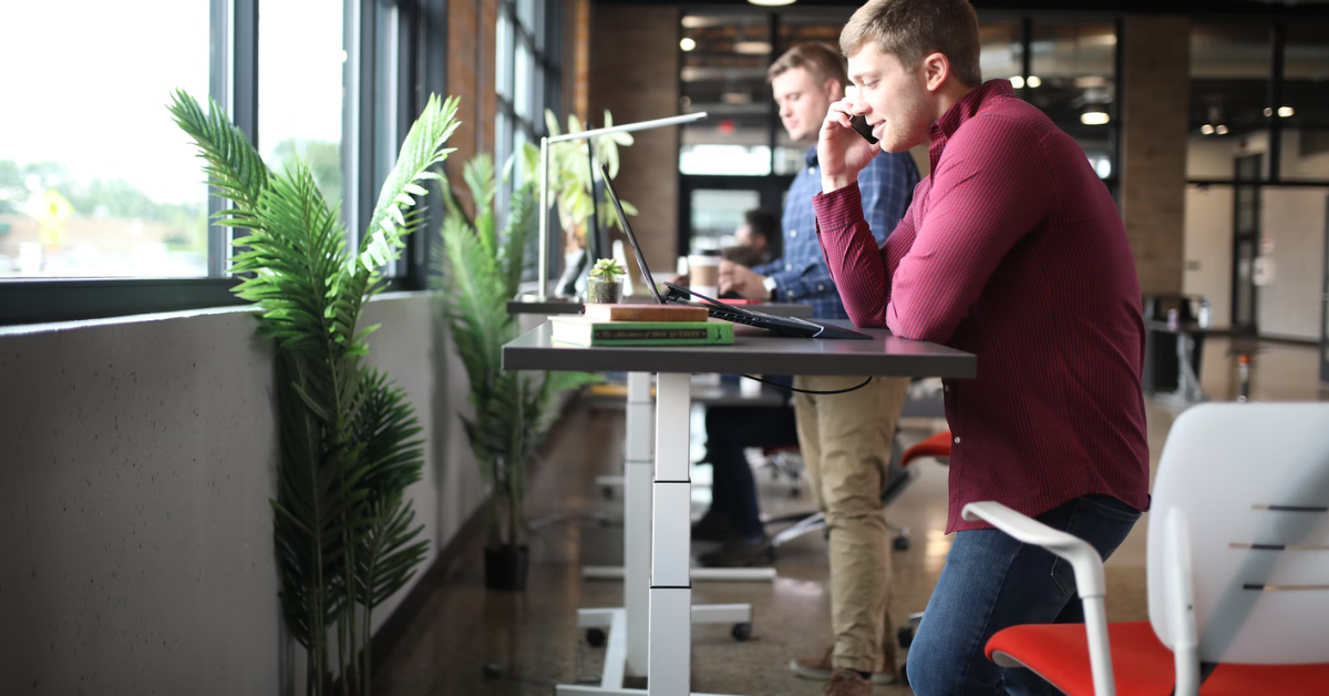 A man making a phone call while working on a standing deks