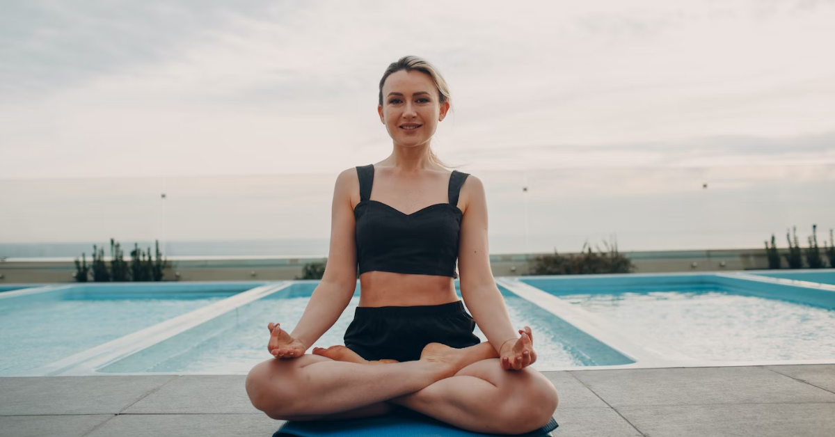 woman sitting Indian style near pool