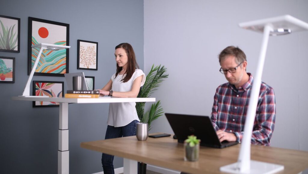 Office workers standing on the desk and sitting on the chair