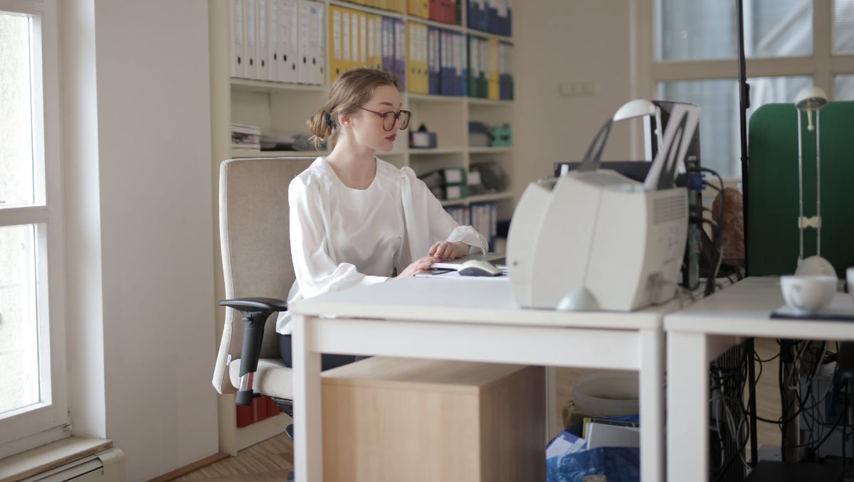 A woman working on her desk inside the office.