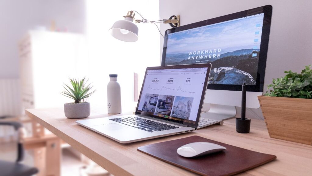 A close up of desk size with laptop and desktop on hand