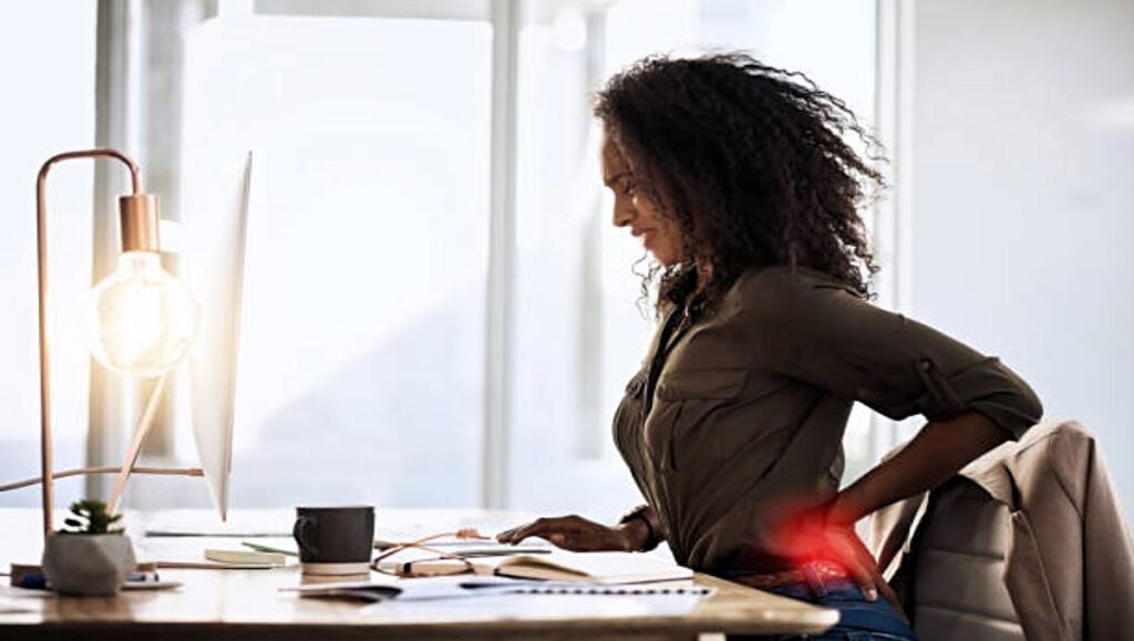 Woman having back pain in the office