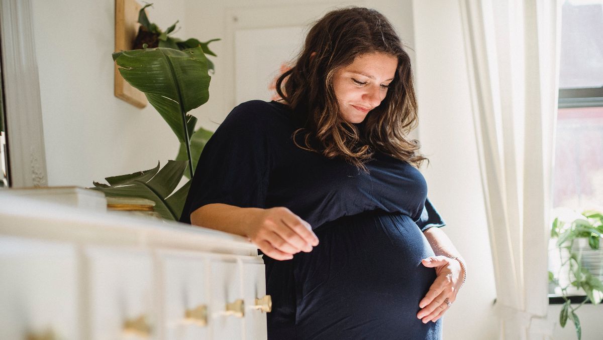 A pregnant woman holding her belly.