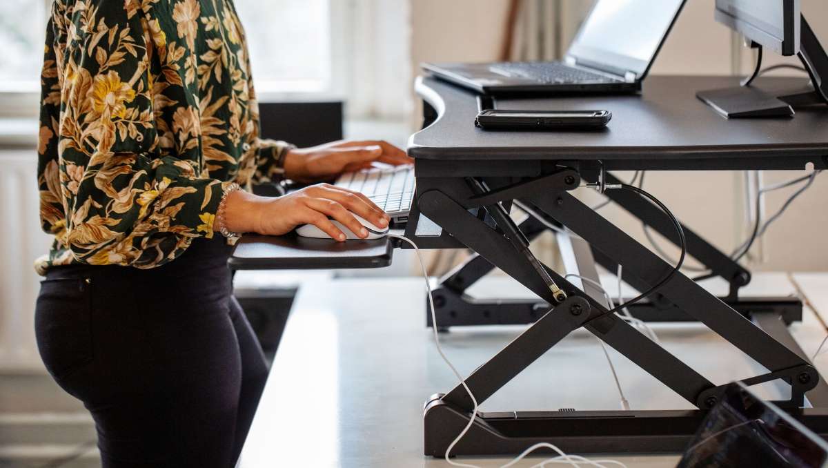 A woman working on a standing desk.