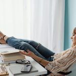 Woman Sitting in an Office Chair with Feet on Table