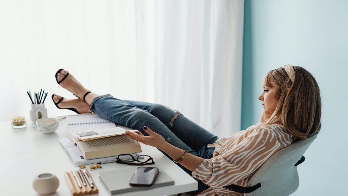 Woman Sitting in an Office Chair with Feet on Table