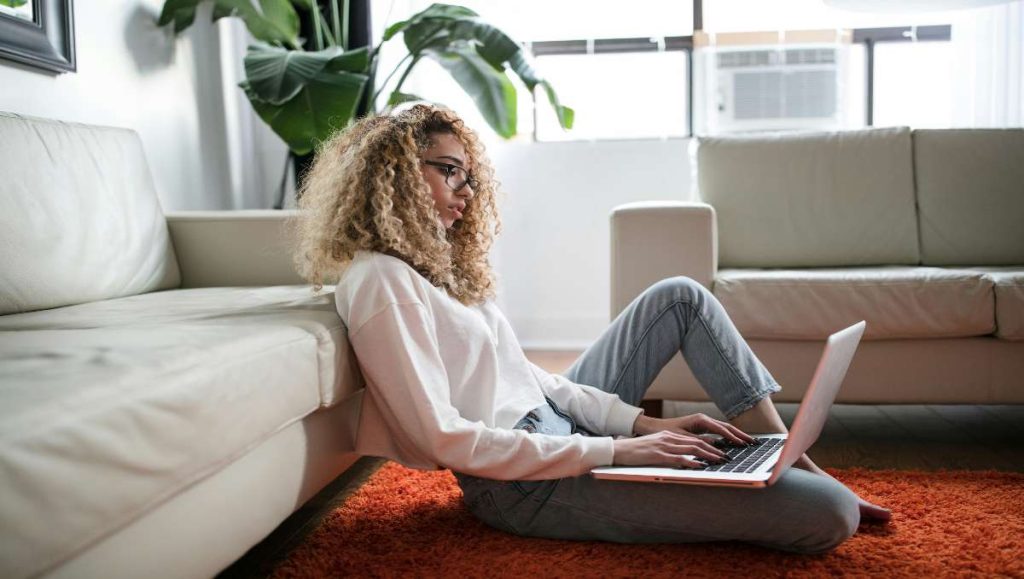 Tall girl sitting on the floor while working