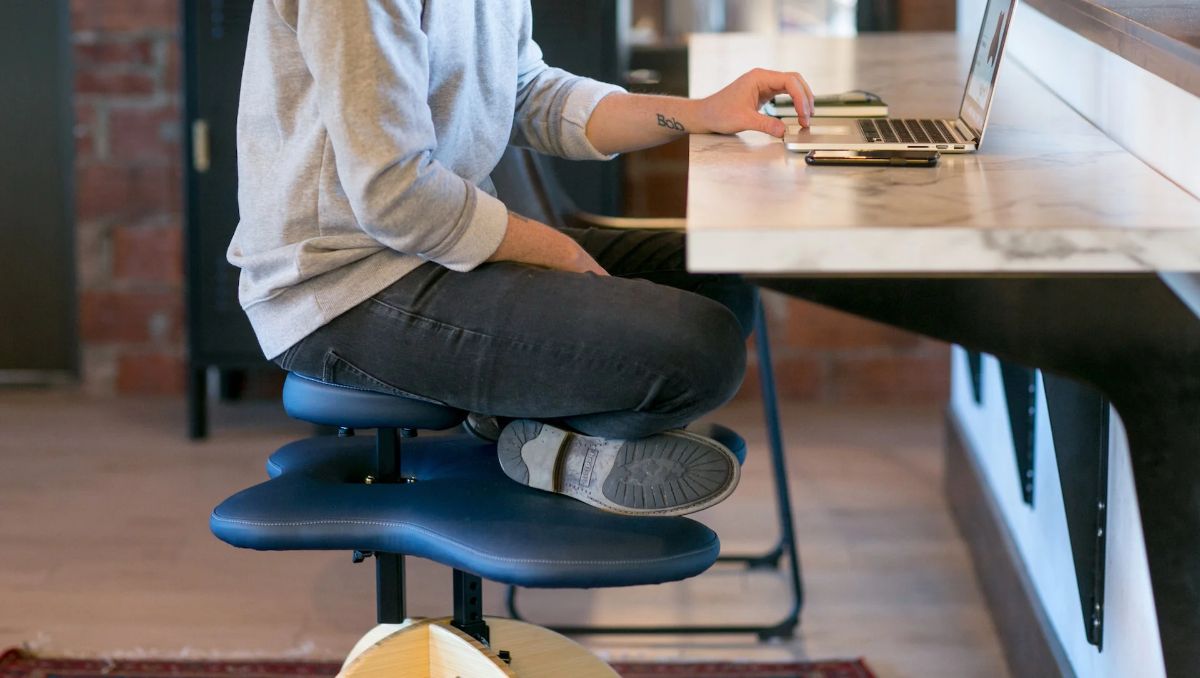 A guy sitting on a cross-legged chair