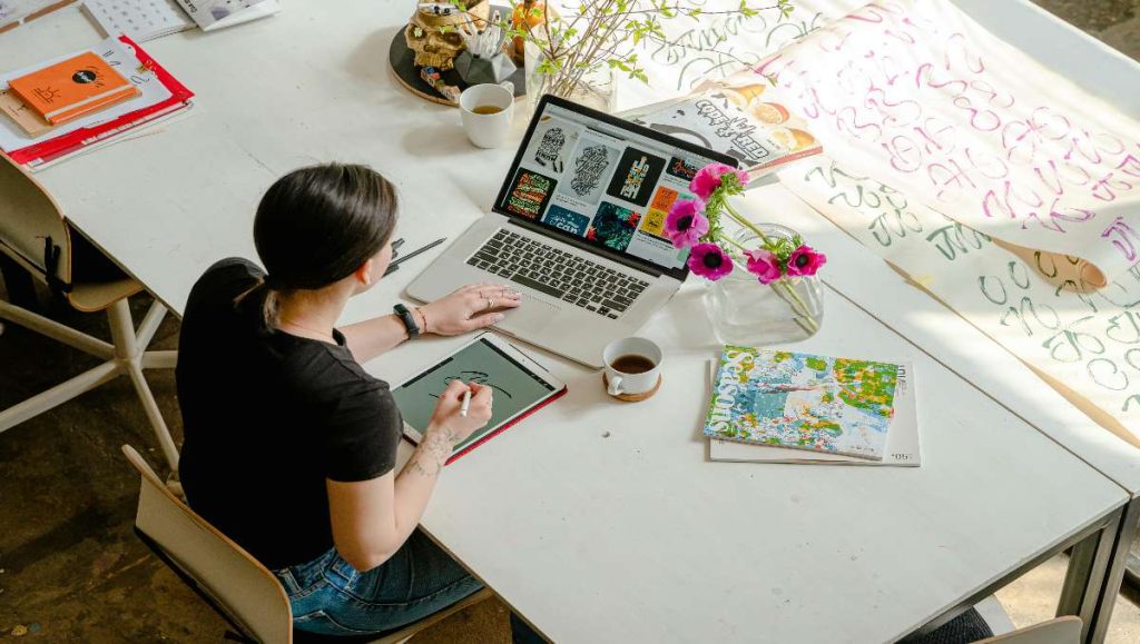 minimum desk depth Woman working in white desk with laptop