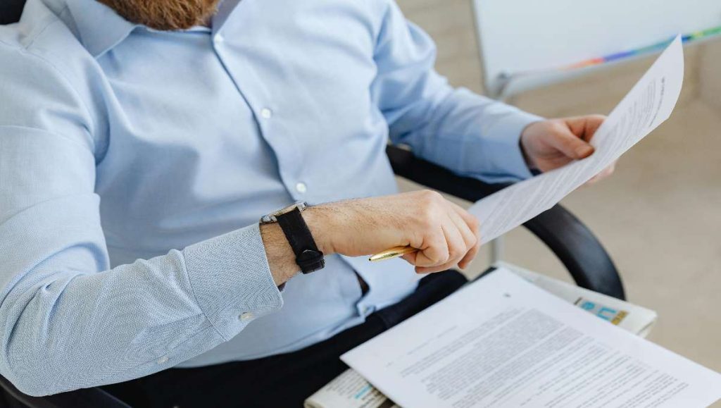 Man holding paper while sitting in office chair