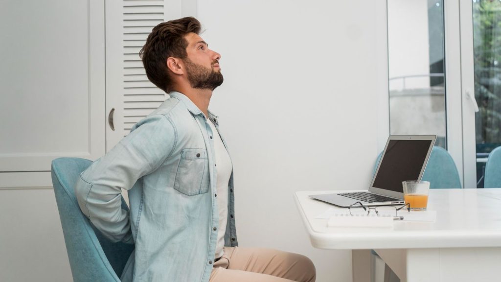 Man having back pain and spinal issues while working