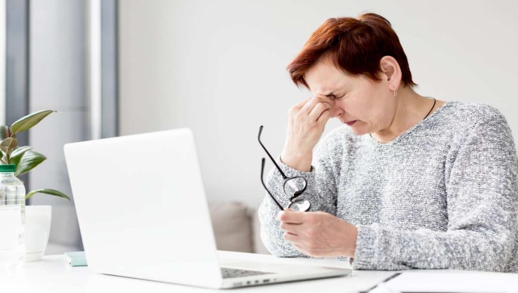 Woman having eye strain while working