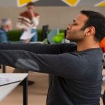 Man stretching in his office