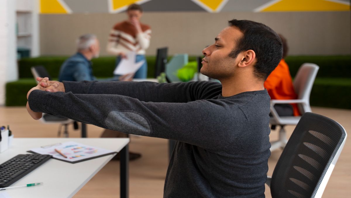 Man stretching in his office