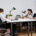 Four workers sitting in office chair