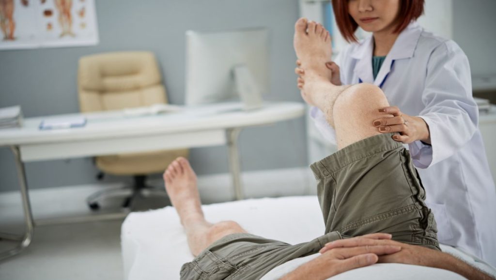 office chair to prevent leg swelling Doctor doing leg therapy to male patient