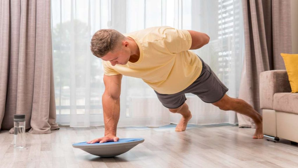 balance board exercises Man doing bird dog balance board exercises