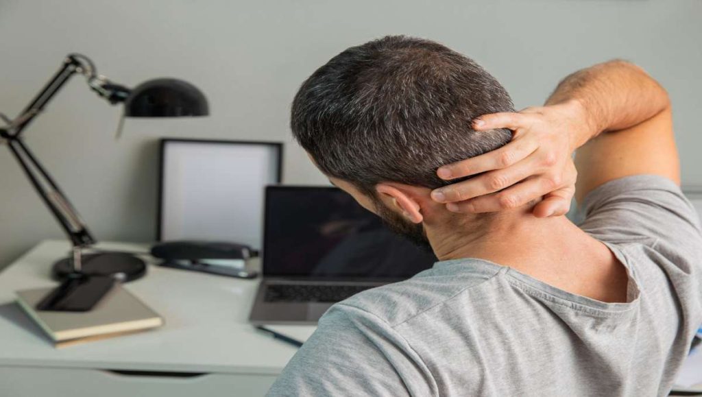 office chair stretches Man doing neck stretch while working