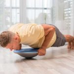 Man doing balance board exercise in the room
