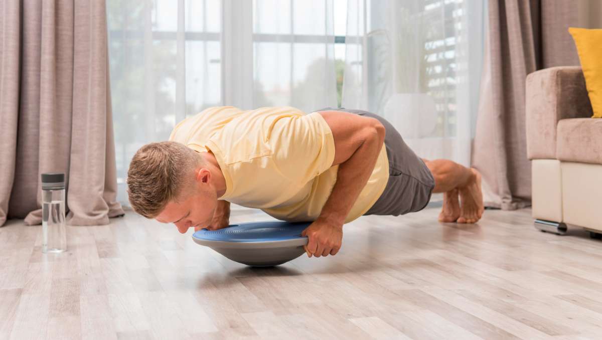 Man doing balance board exercise in the room
