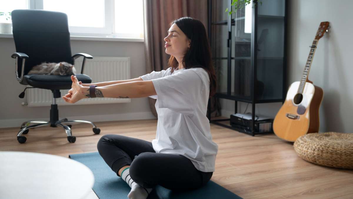 Girl stretching on the floor beside the office chair