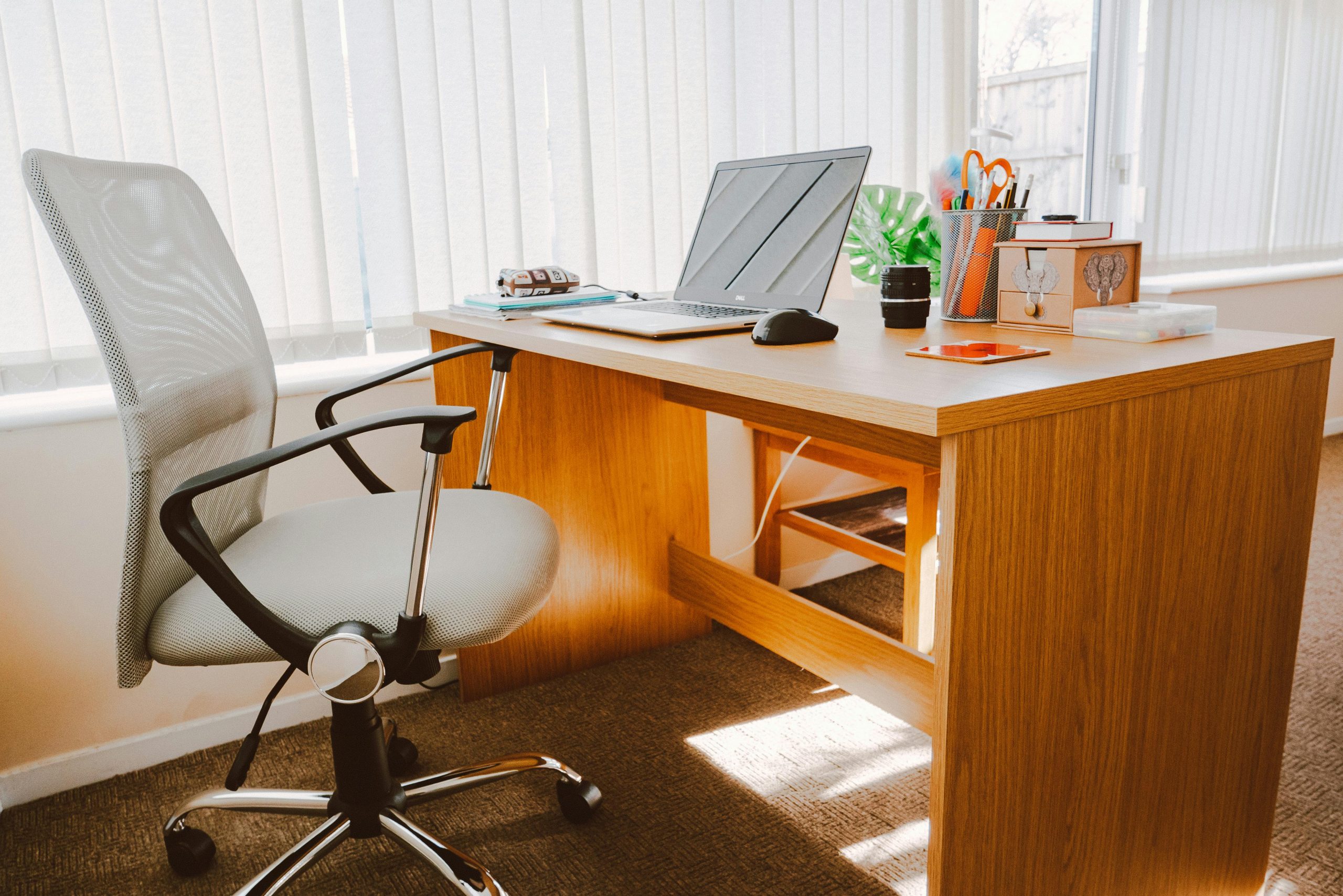 a high back chair next to a wooden desk in office
