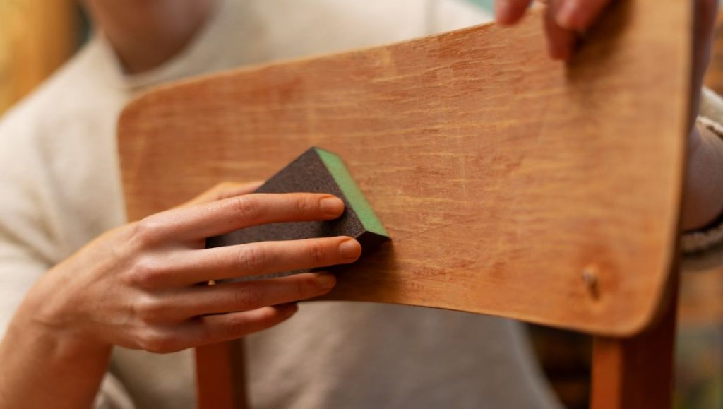 Man wiping chair doing furniture maintenance
