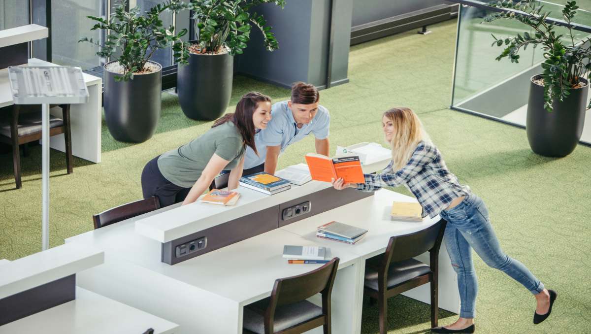 Three employees in an office with collaborative furniture