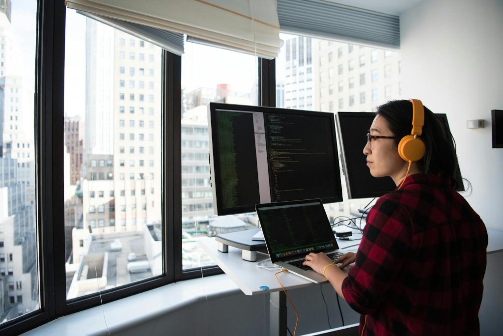 Girl wearing headphone and focused outside while working on a standing desk