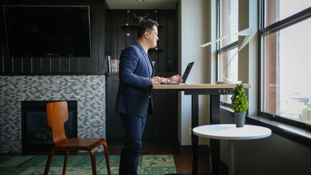 Man in blue suit working on a standing desk
