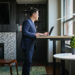 Man in blue suit working on a standing desk