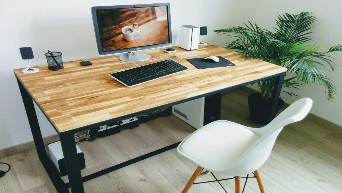 Amish wooden desk setup at home with white chair and computer on top