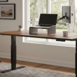 A walnut standing desk setup at home facing the window