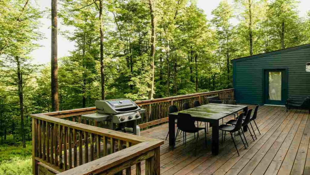 An outdoor deck with dining table in the forest
