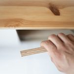 A hand holding a piece of plywood