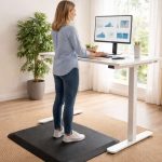Woman working on a standing desk while using an anti-fatigue mat