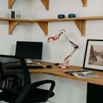 A corner desk setup with laptop and office chair