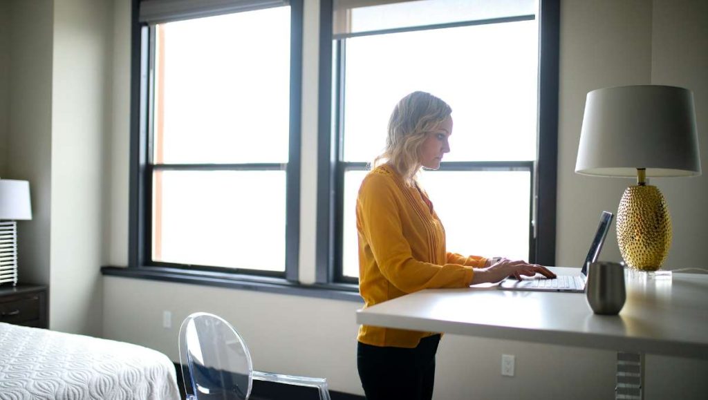 Girl in yellow working on a standing desk at home