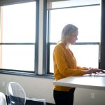 Girl in yellow working on a standing desk at home