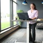 Woman smiling while working at the standing desk