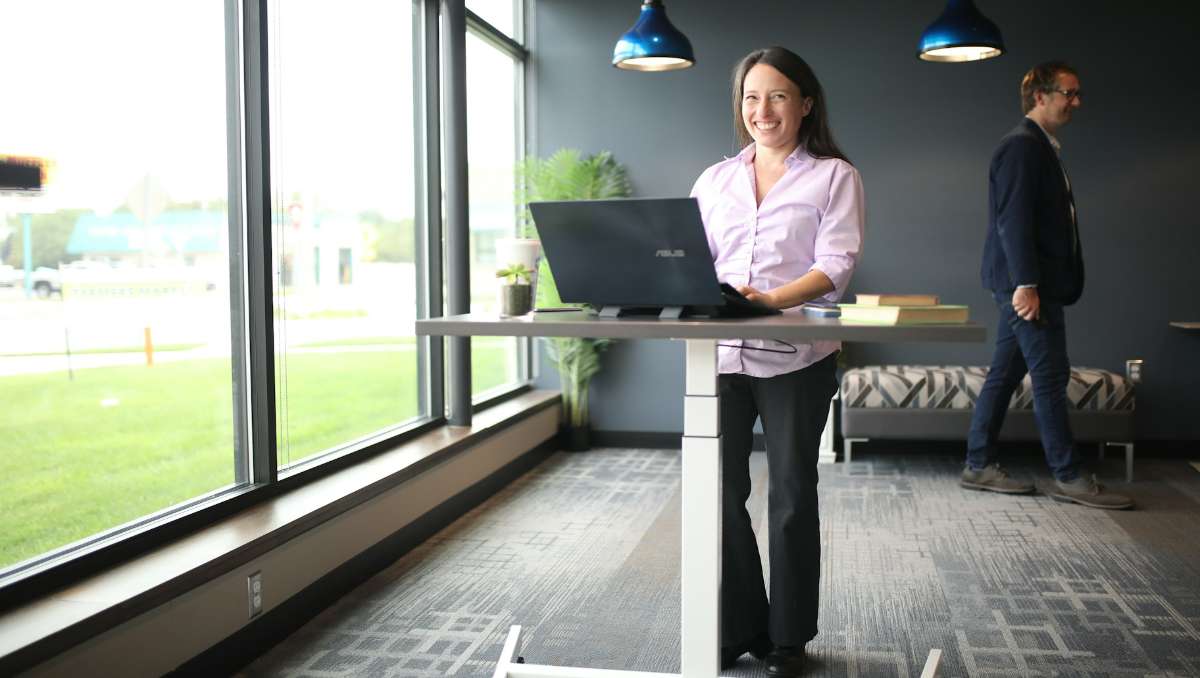 Woman smiling while working at the standing desk