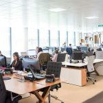 Full office with workers and wooden desk