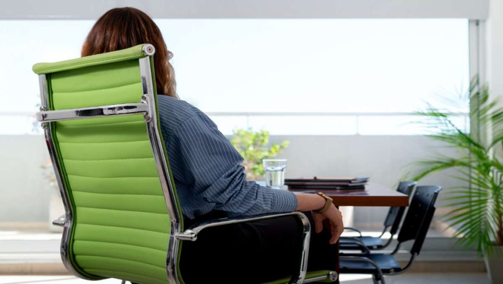 Worker sitting on office chair with lumbar support