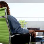 Worker sitting on office chair with lumbar support