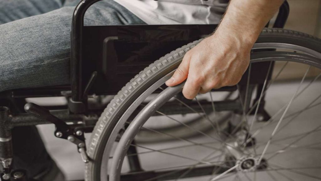 standing table for disabled Disabled man holding wheel of the wheelchair
