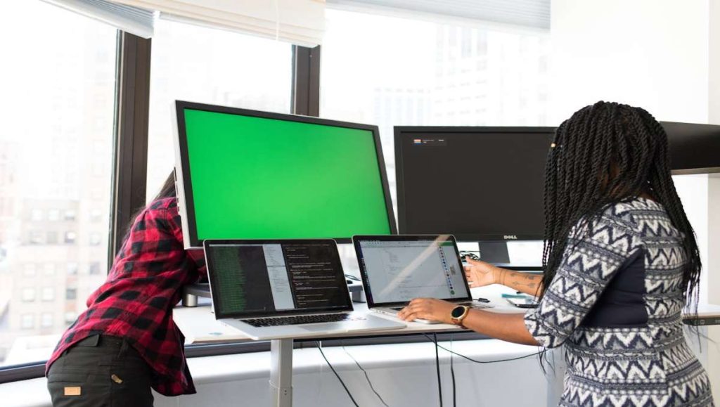 Two woman working on a standing desk